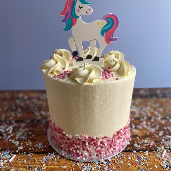 Tall Buttercream Cake with Unicorn Topper and Pink Sprinkles