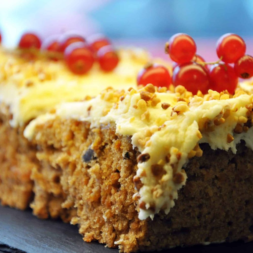 Carrot cake slice with cream cheese and red berries